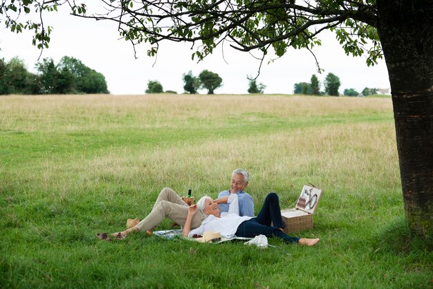 Adorable pareja senior haciendo un picnic al aire libre