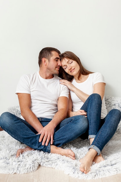 Adorable pareja sentada sobre una manta