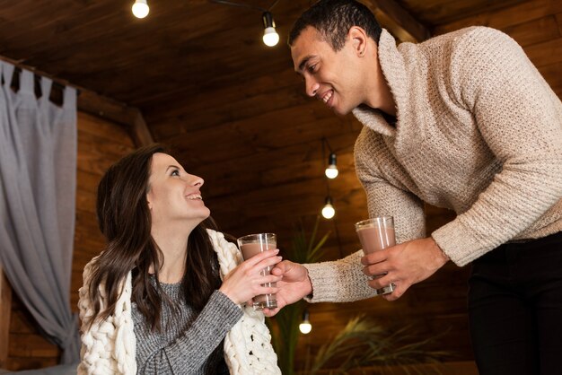 Adorable pareja tomando bebidas calientes