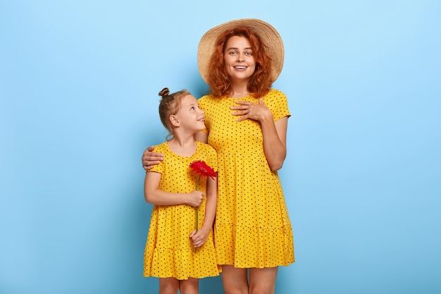 Adorable pelirroja madre e hija posando en vestidos similares