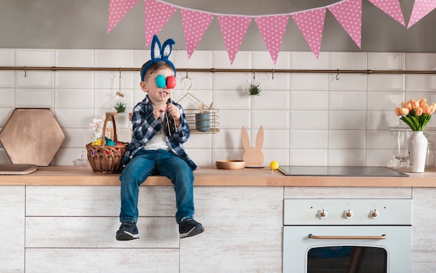 Adorable pequeño jugando con huevos de pascua