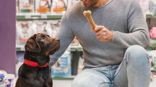 Adorable perro con dueño en la tienda de mascotas