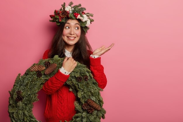 Adorable señorita sonríe agradablemente vistiendo una corona festiva en la cabeza