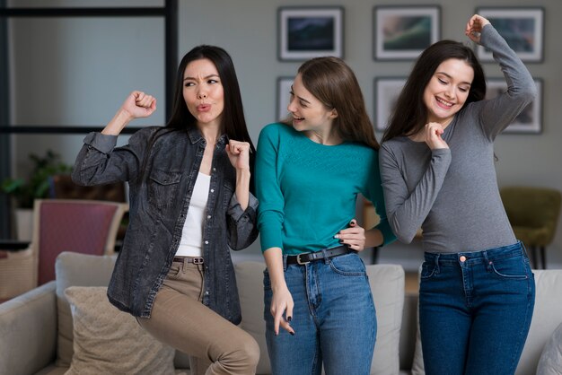 Adorables mujeres jóvenes jugando juntas en casa