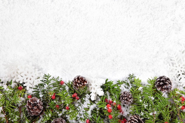 Adornos de navidad con piñas sobre la nieve