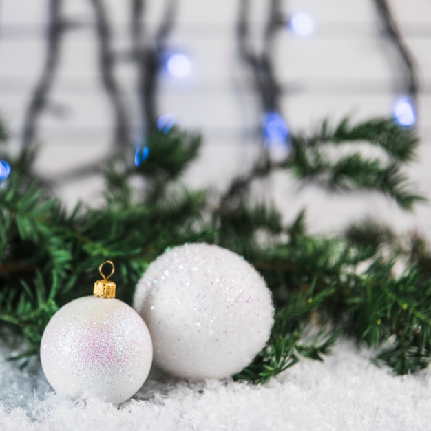 Foto gratuita adornos navideños cerca de rama de abeto en la nieve