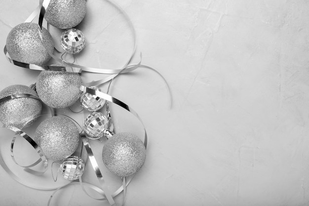 Adornos navideños de plata sobre mesa blanca