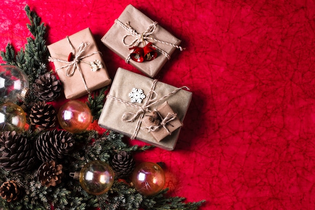 Adornos navideños sobre fondo rojo con regalos envueltos