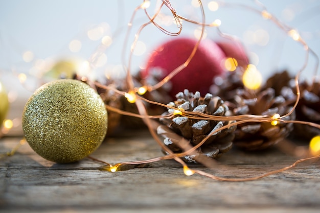 Adornos navideños sobre una mesa de madera y una bola de navidad dorada