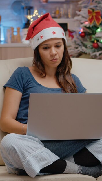 Adulto aburrido con laptop y mirando películas en la televisión