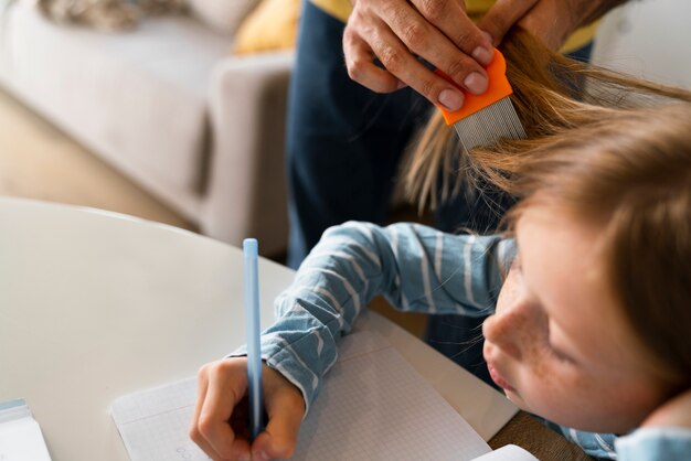 Adulto de alto ángulo ayudando a niño con piojos