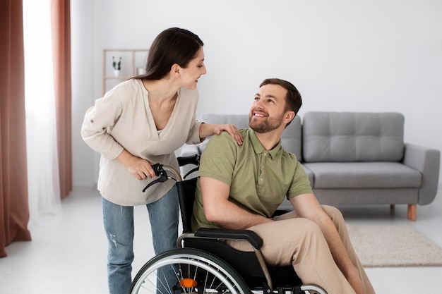 Adulto joven ayudando a un amigo discapacitado