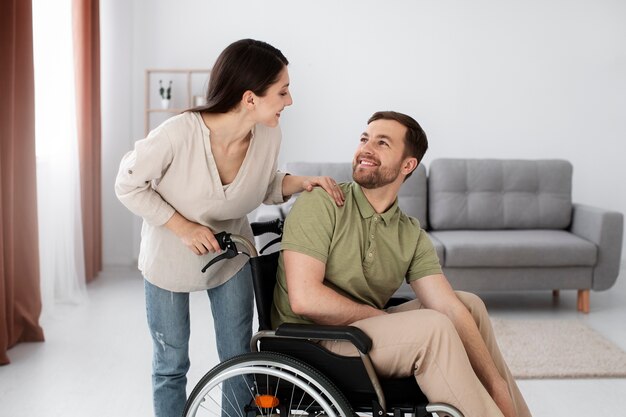 Adulto joven ayudando a un amigo discapacitado