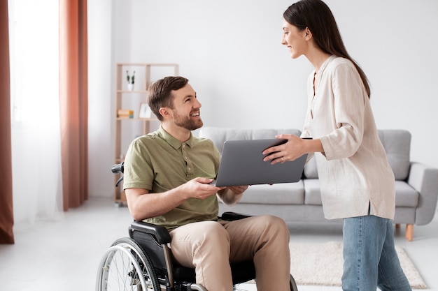 Adulto joven ayudando a un amigo discapacitado