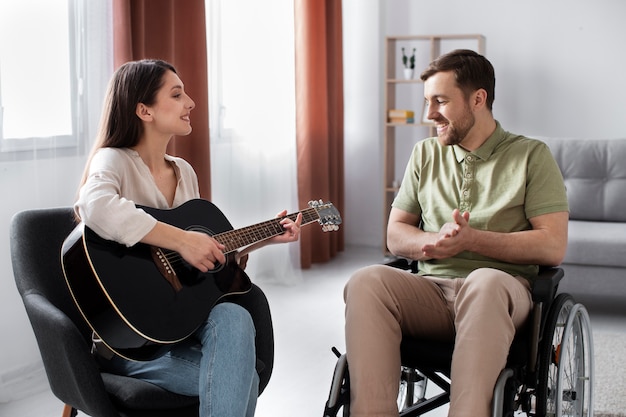 Foto gratuita adulto joven ayudando a un amigo discapacitado