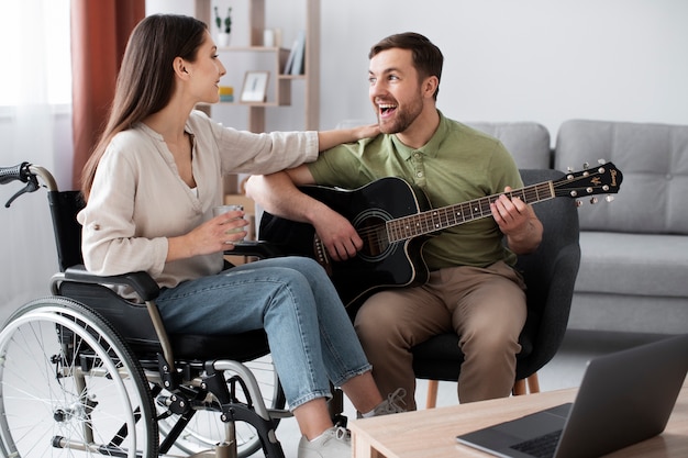 Adulto joven ayudando a un amigo discapacitado