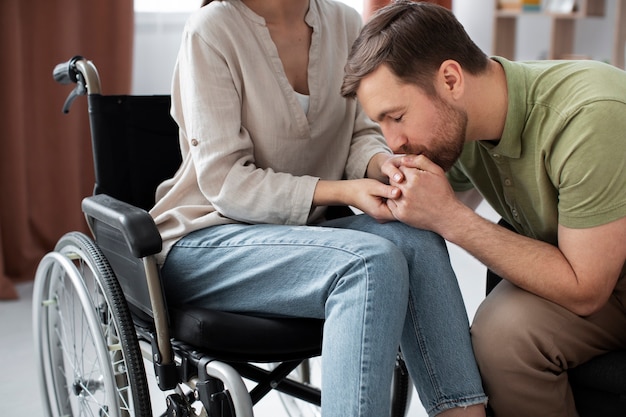 Foto gratuita adulto joven ayudando a un amigo discapacitado