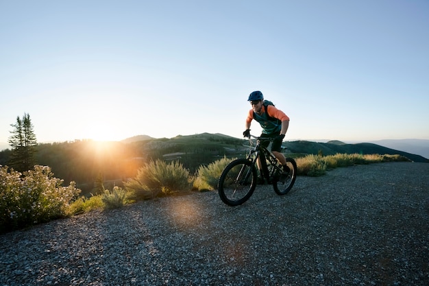 Adulto joven con bicicleta eléctrica en el campo