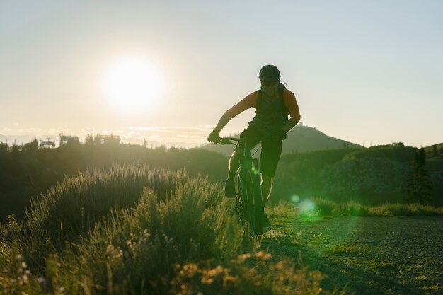 Adulto joven con bicicleta eléctrica en el campo