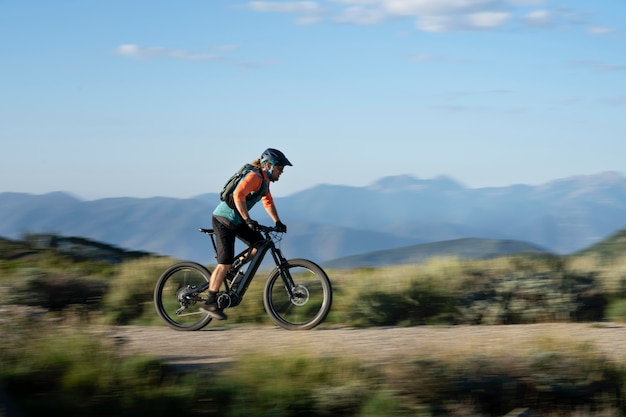 Adulto joven con bicicleta eléctrica en el campo