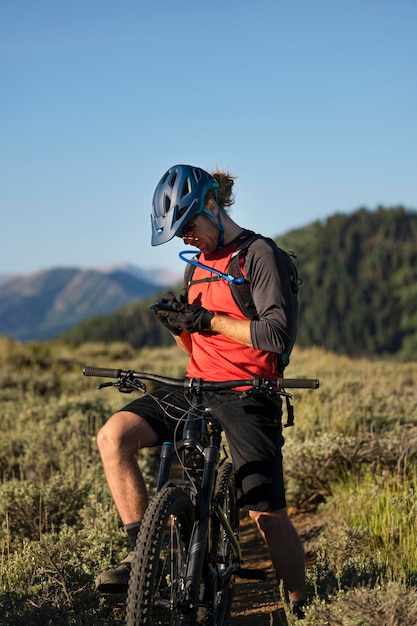 Adulto joven con bicicleta eléctrica en el campo