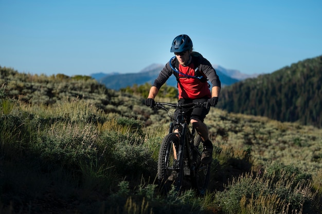 Foto gratuita adulto joven con bicicleta eléctrica en el campo