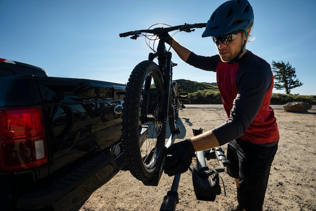 Adulto joven con bicicleta eléctrica en el campo