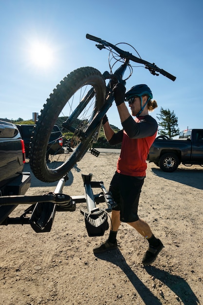 Adulto joven con bicicleta eléctrica en el campo