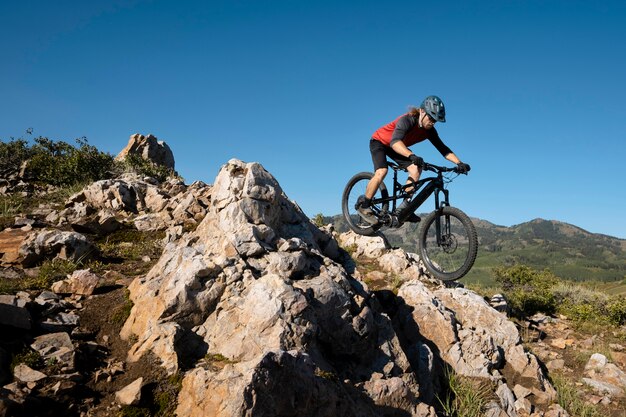 Adulto joven con bicicleta eléctrica en el campo