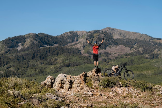 Foto gratuita adulto joven con bicicleta eléctrica en el campo