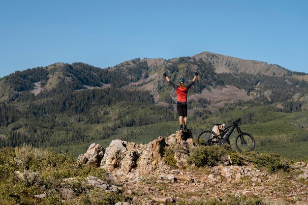 Adulto joven con bicicleta eléctrica en el campo