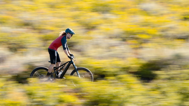 Adulto joven con bicicleta eléctrica en el campo