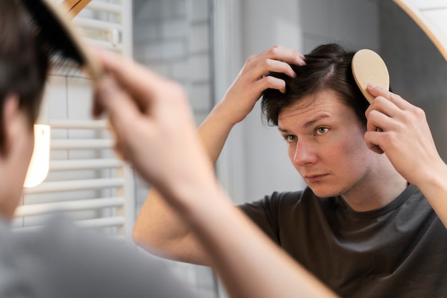 Adulto joven cepillando su cabello