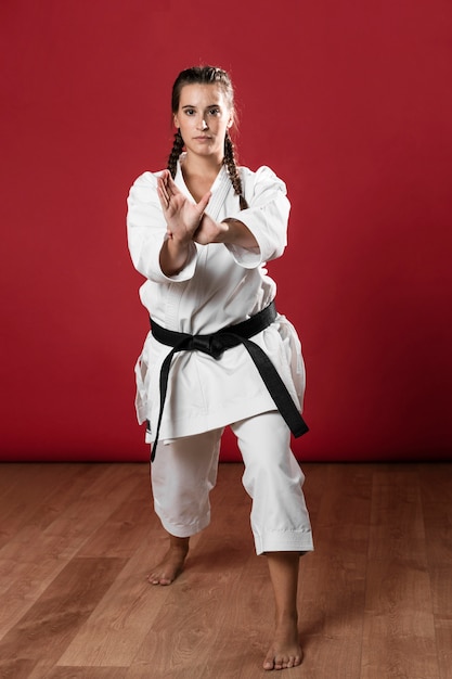 Adulto joven con cinturón negro luchador karate de entrenamiento