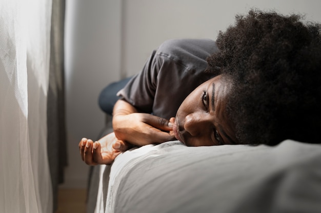 Foto gratuita adulto joven y deprimido en casa