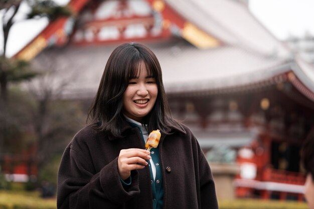 Adulto joven disfrutando de comida callejera japonesa