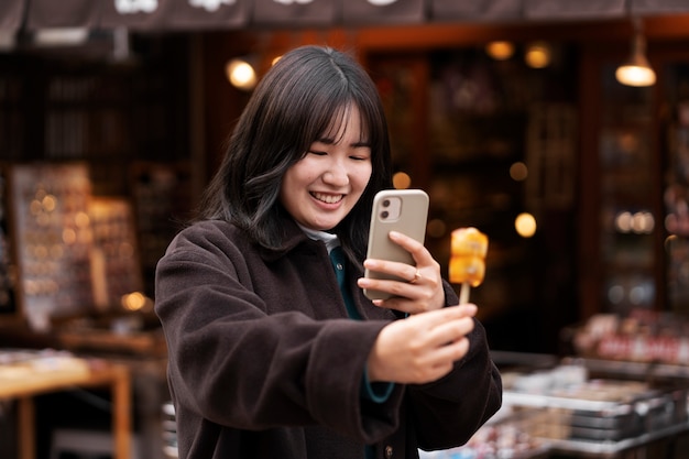 Adulto joven disfrutando de comida callejera japonesa