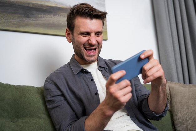 Adulto joven disfrutando jugando videojuegos