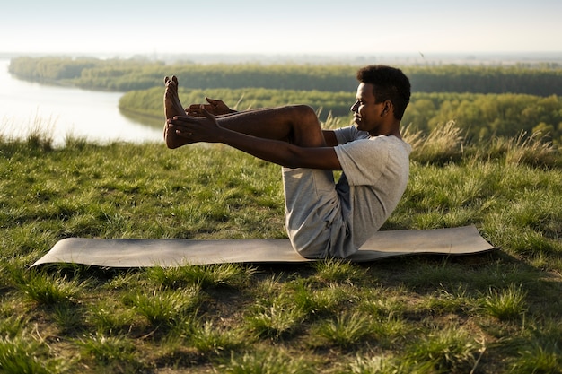 Foto gratuita adulto joven disfrutando del yoga en la naturaleza