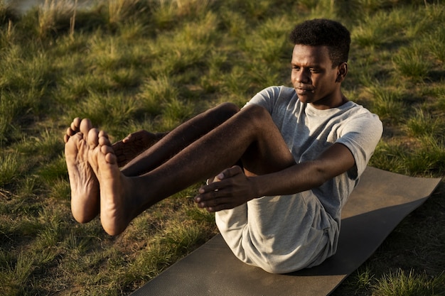 Adulto joven disfrutando del yoga en la naturaleza