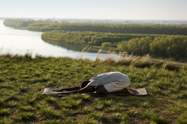 Foto gratuita adulto joven disfrutando del yoga en la naturaleza