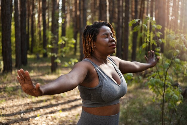 Adulto joven disfrutando del yoga en la naturaleza