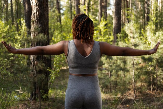 Adulto joven disfrutando del yoga en la naturaleza