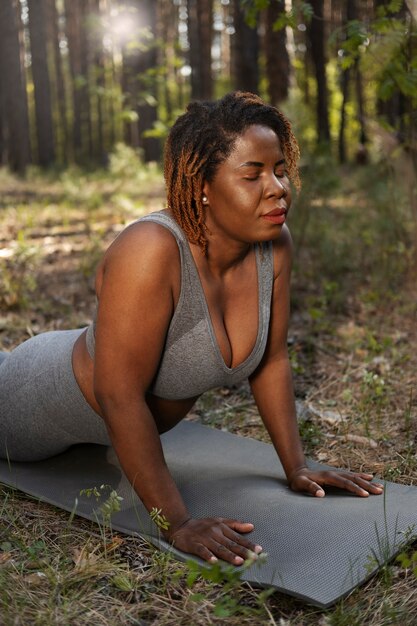 Adulto joven disfrutando del yoga en la naturaleza