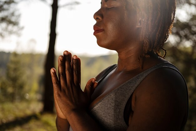 Adulto joven disfrutando del yoga en la naturaleza