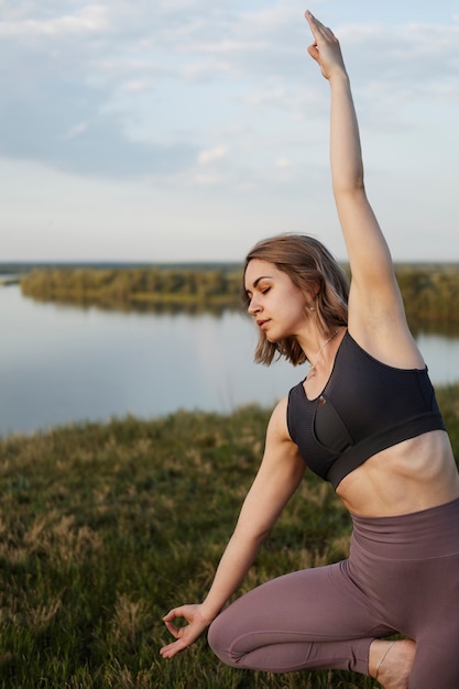 Adulto joven disfrutando del yoga en la naturaleza