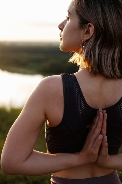 Adulto joven disfrutando del yoga en la naturaleza