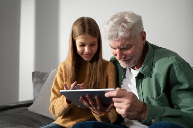 Foto gratuita adulto joven enseñando a anciano sobre devicer degital