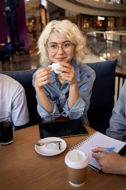 Foto gratuita adulto joven estudiando en un café