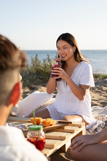 Adulto joven con una fiesta de sangría en la playa